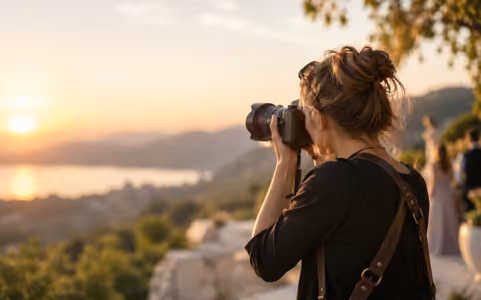 Professional photographer taking a photo outdoors at golden hour.